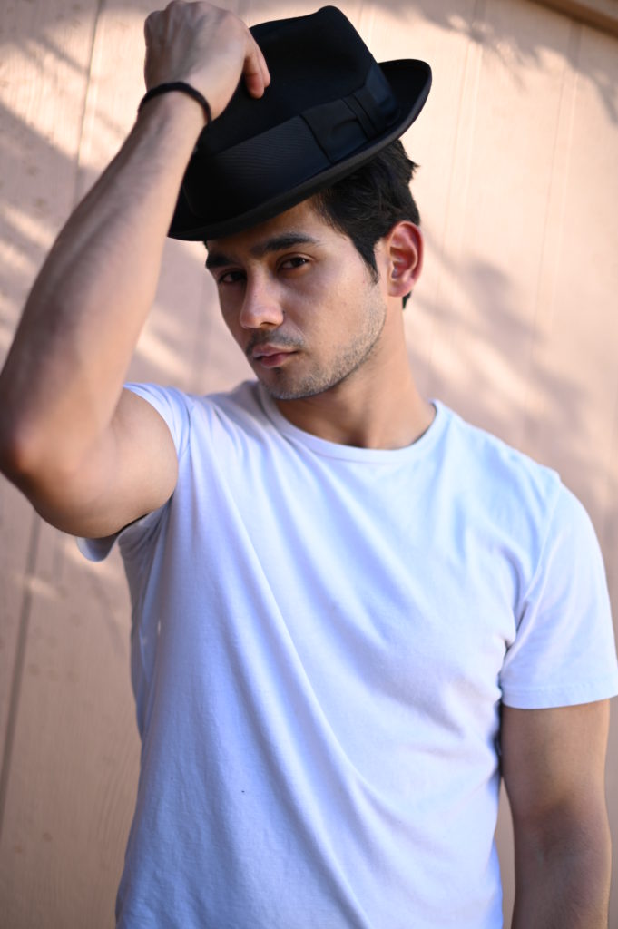 Dipanshu Sharma standing with his hand on a hat