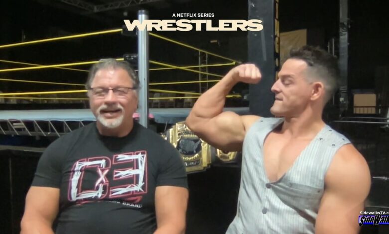 Al Snow and Mr PEC-Tacular Jessie Godderz showing his pecs to the audience.