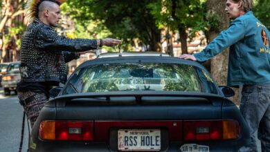 Matt Smith and Austin Butler standing next to a car in a still image from the film