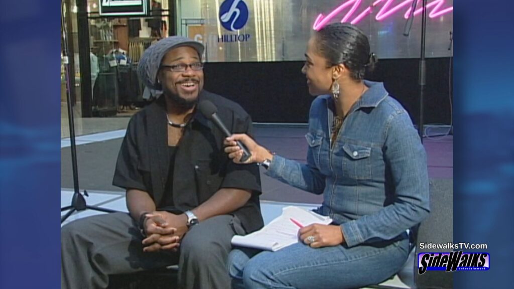 Malcolm-Jamal Warner and host Eboni Warnking  sitting on the stage.