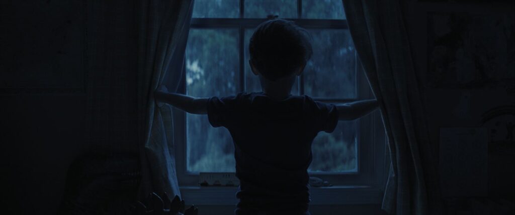 CARY CHRISTOPHER standing at a window in a still image from Weapons