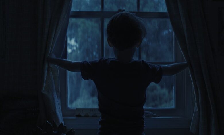 CARY CHRISTOPHER standing at a window in a still image from Weapons