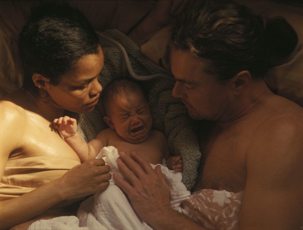 TEYANA TAYLOR and LEONARDO DI CAPRIO holding a baby in a still from the movie.