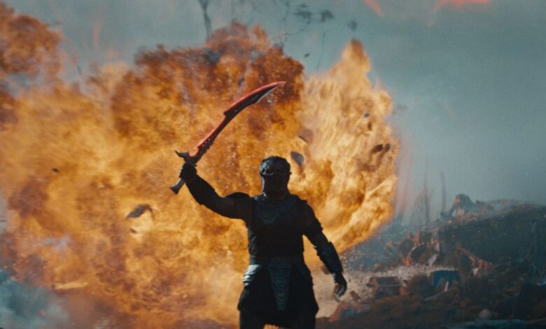 PREDATOR: BADLANDS with fire behind the creature