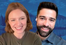 Close-up of Scarlet Hunter and Markian Tarasiuk smiling against a blue-tinted mountain and lake background.