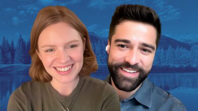 Close-up of Scarlet Hunter and Markian Tarasiuk smiling against a blue-tinted mountain and lake background.