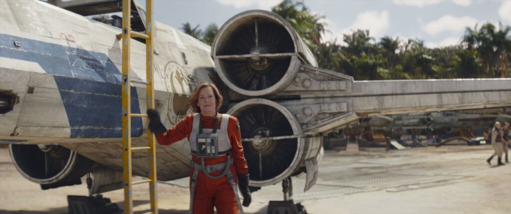 Colonel Ward (Sigourney Weaver) stands next to her X-Wing fighter.
