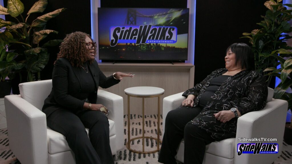 Charisse Arrington interviewing Martha Wash on a set with a monitor in the background with the Sidewalks logo.