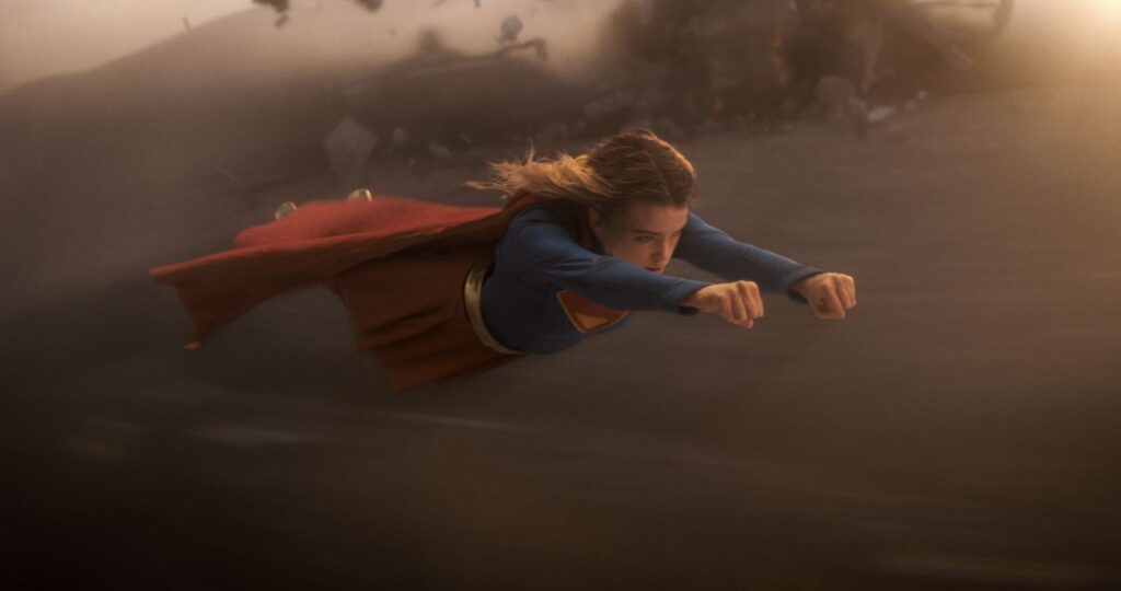 Milly Alcock as SUPERGIRL flying in the sky.