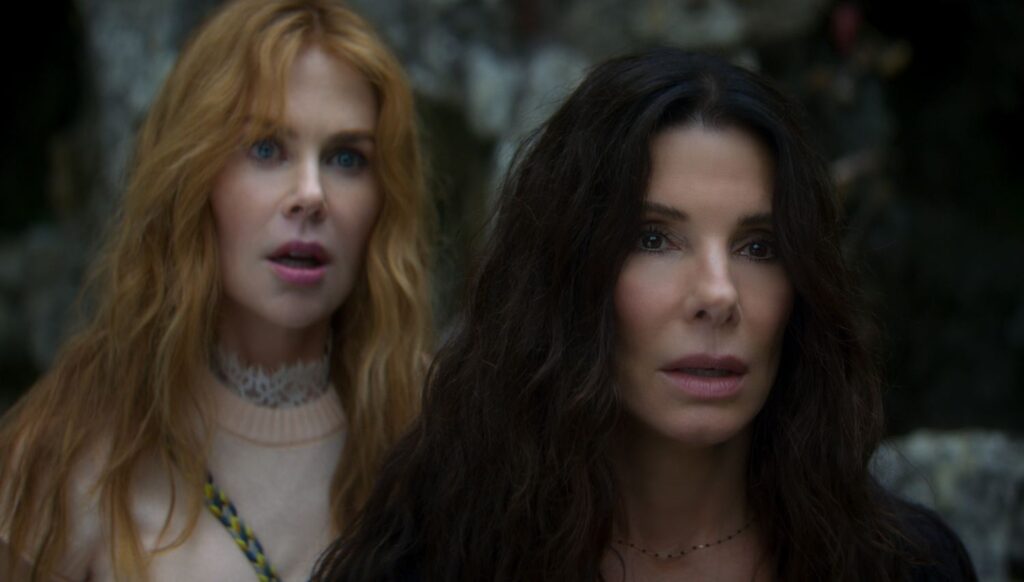 NICOLE KIDMAN as Gillian Owens and SANDRA BULLOCK as Sally Owens standing next to each other.