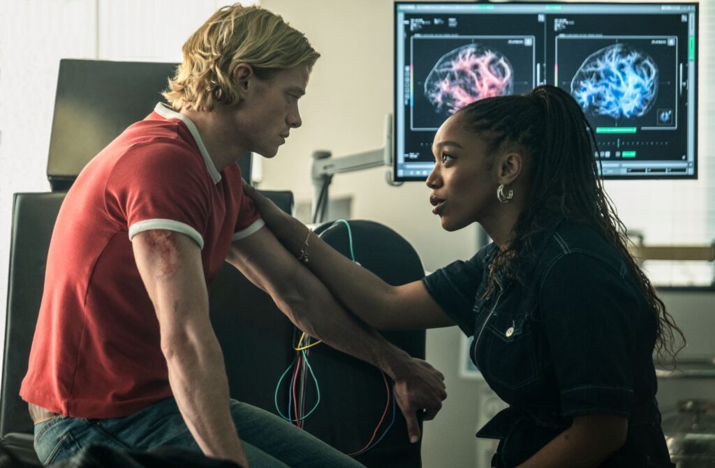 TOM RHYS HARRIES as Matt Hagen and NAOMI ACKIE as Caitlyn Corr looking at each other.