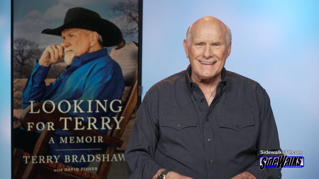 Terry Bradshaw smiling with his book cover on the monitor behind him.